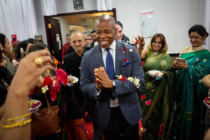 Mayor Eric Adams clasps his hands and smiles during a Diwali celebration in Queens.